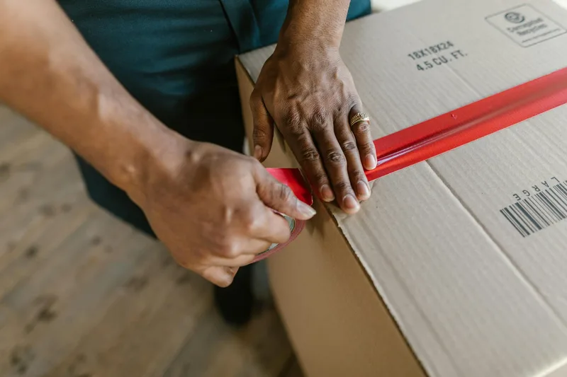 Seller Indonesia mengemas produk Shopee dengan rapi dalam kotak sebelum diserahkan ke kurir pickup