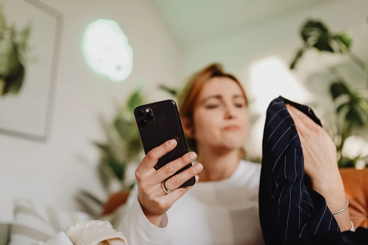 Wanita menggunakan smartphone untuk berbelanja online, mewakili pengguna Shopee Indonesia yang ingin mengelola riwayat belanja