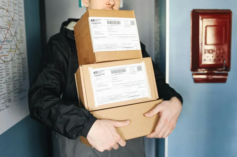 Courier packages and delivery boxes stacked with shipping labels, ready for pickup by a logistics provider