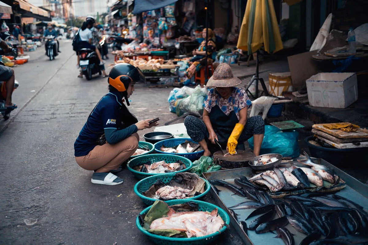 Outdoor marketplace sellers displaying mobile phones and electronics at a street bazaar, representing the marketplace selling environment in Southeast Asia