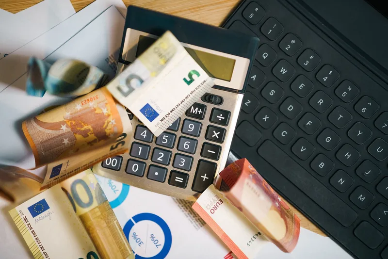 Business person reviewing pricing documents and fee calculations on office desk