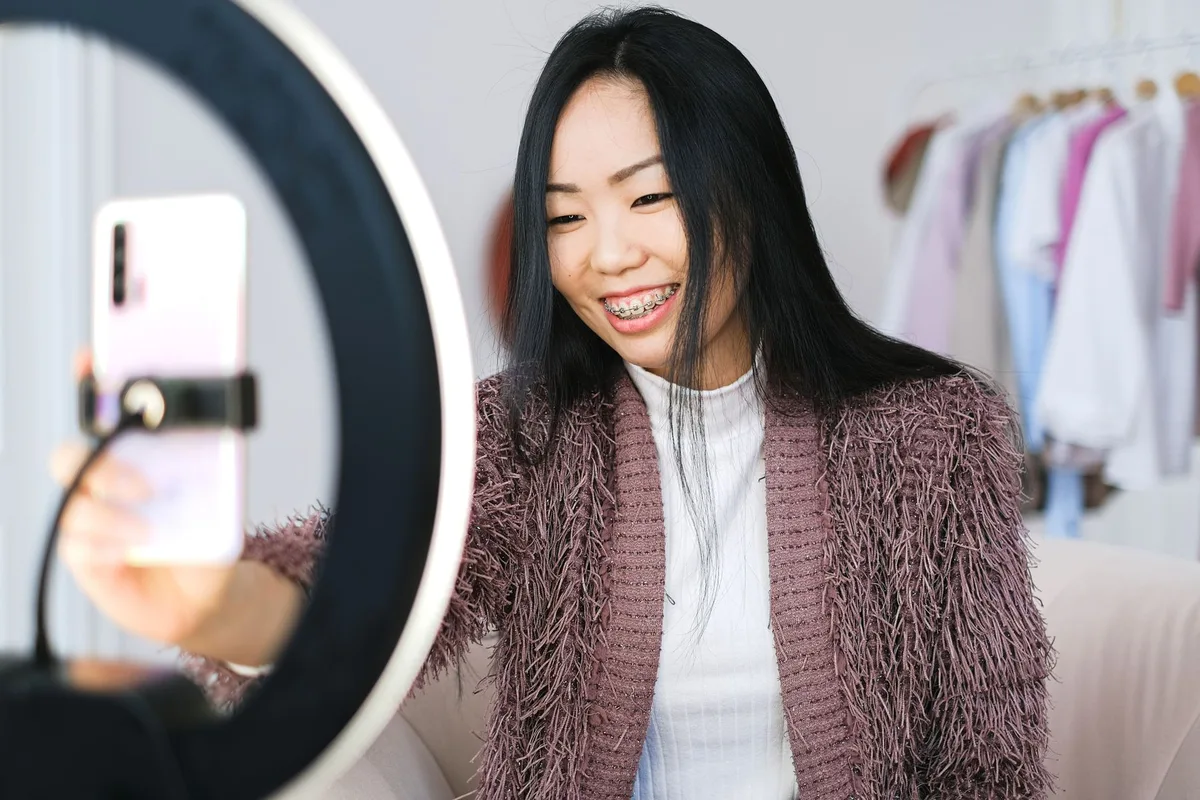 Seller preparing a Shopee Live session using a smartphone and ring light